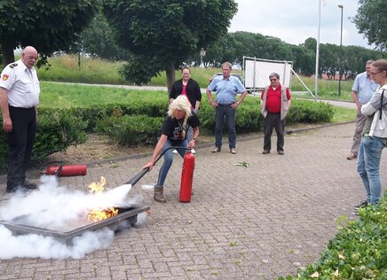 Brand wordt geblust door vrouw met omstanders