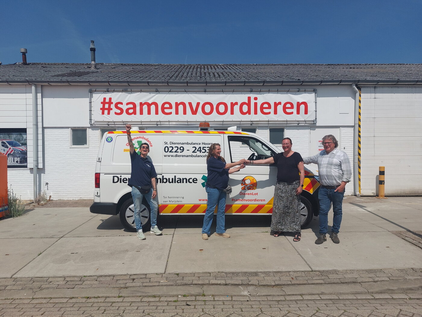 Overhandiging sleutels voor dierenambulance tussen 3 vrouwen en 1 man